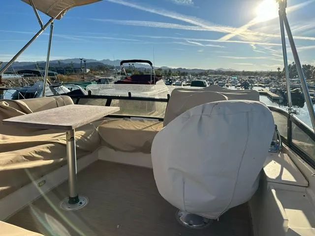 Slide: The Image of 2016 Carver C34 Command Bridge boat with covered seating and table, docked under sunny skies. - 8