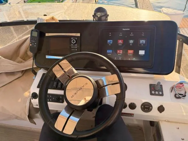 Slide: The Image of Helm of 2016 Carver C34 Command Bridge with modern navigation controls and steering wheel. - 11