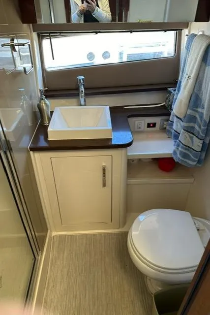 Slide: The Image of 2016 Carver C34 Command Bridge bathroom with modern sink, toilet, and window. - 22
