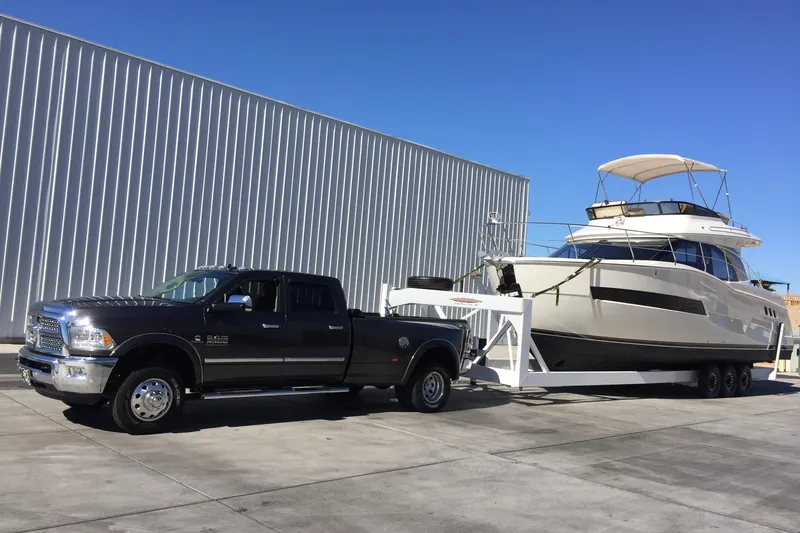 Slide: The Image of Truck towing 2016 Carver C34 Command Bridge yacht on trailer, parked by metal building. - 32