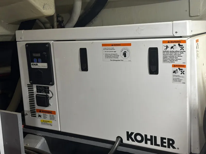 Slide: The Image of Kohler generator in 2016 Carver C34 Command Bridge engine room, featuring warning labels. - 36