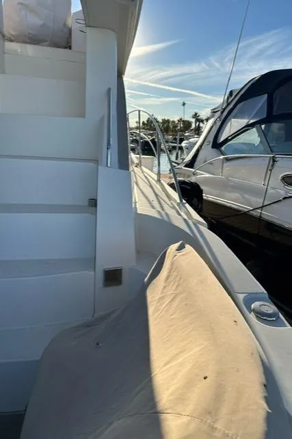 Slide: The Image of 2016 Carver C34 Command Bridge yacht docked, featuring stairs and marina view. - 9