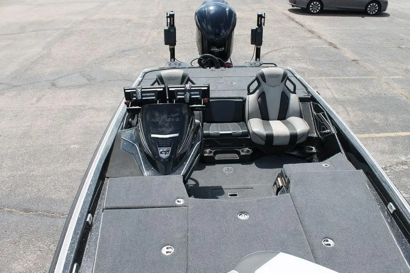 Slide: The Image of 2021 Skeeter FXR21 boat interior with seating and control panel in a parking lot. - 4
