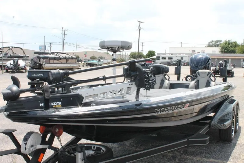 Slide: The Image of 2021 Skeeter FXR21 bass boat with Garmin and Minn Kota accessories in a parking lot. - 5
