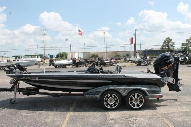 Slide: The Image of 2021 Skeeter FXR21 bass boat on trailer, parked outdoors under a clear sky. - 7