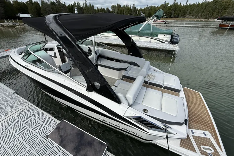 Slide: The Image of 2016 Regal 2500 Bowrider boat docked on a calm lake with forest backdrop. - 2