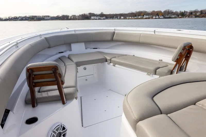 Slide: The Image of 2022 Sportsman Open 352 Center Console boat interior with cushioned seating and wooden accents. - 14