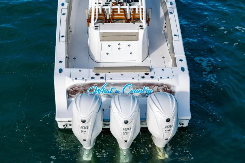 Slide: The Image of 2022 Sportsman Open 352 Center Console boat with triple 300 HP engines on water. - 45