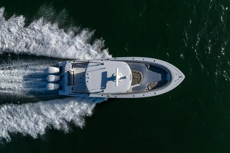Slide: The Image of Aerial view of 2022 Sportsman Open 352 Center Console boat speeding on water. - 47