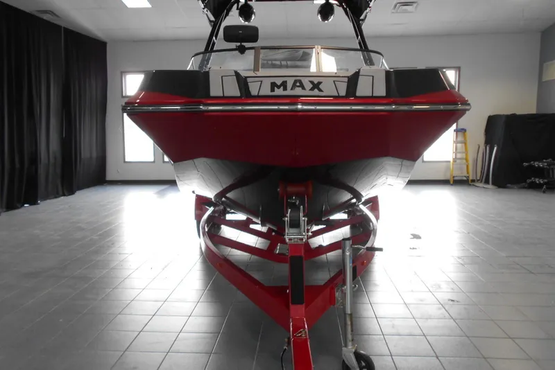 Slide: The Image of 2023 Moomba Max boat in showroom, front view, red and black design. - 2
