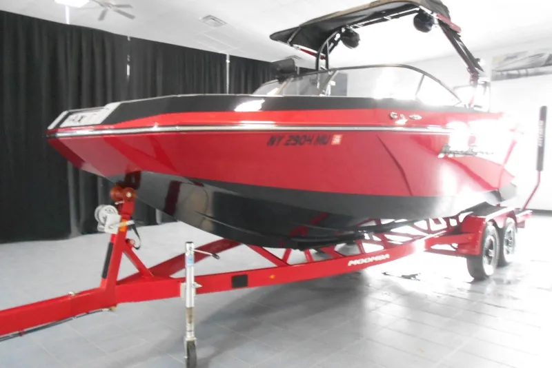 Slide: The Image of 2023 Moomba Max boat in showroom, red and black design on trailer. - 3