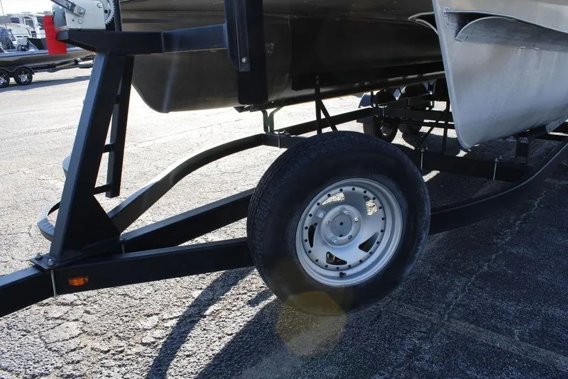 Slide: The Image of 2021 SunCatcher Select 22C trailer with sturdy wheel and frame on pavement. - 3