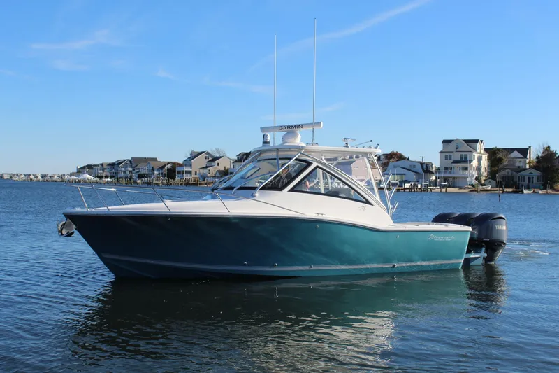 The Image of 2022 Albemarle 30 Express boat on calm water near coastal homes. - 0