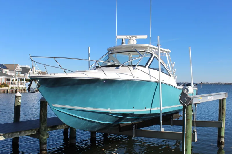 Slide: The Image of 2022 Albemarle 30 Express boat docked on a lift, with a clear blue sky. - 11