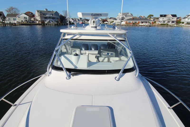 Slide: The Image of 2022 Albemarle 30 Express boat on water, with houses in the background. - 14