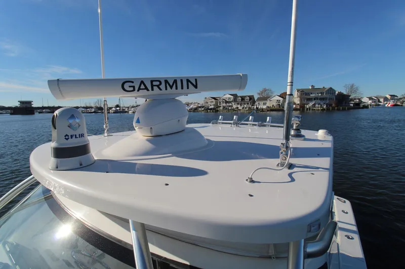 Slide: The Image of 2022 Albemarle 30 Express boat with Garmin and FLIR equipment on deck, docked near waterfront homes. - 16