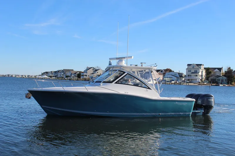 Slide: The Image of 2022 Albemarle 30 Express boat on calm water near coastal homes. - 3