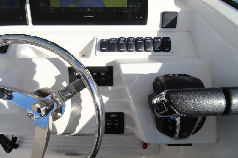 Slide: The Image of 2022 Albemarle 30 Express helm with steering wheel, controls, and Garmin display. - 30