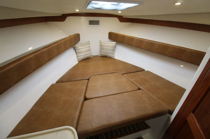 Slide: The Image of 2022 Albemarle 30 Express cabin interior with brown cushions and overhead lighting. - 35