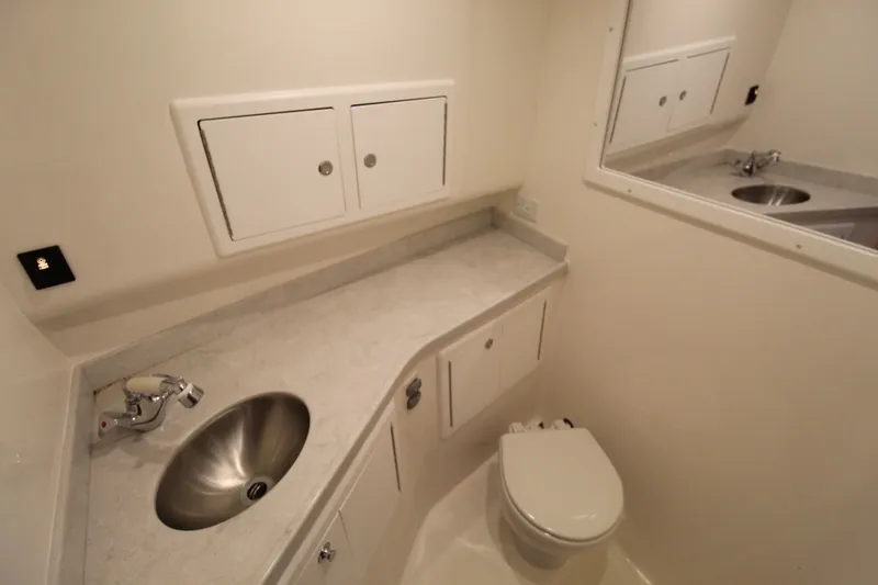 Slide: The Image of 2022 Albemarle 30 Express boat bathroom with sink, toilet, and storage cabinets. - 41