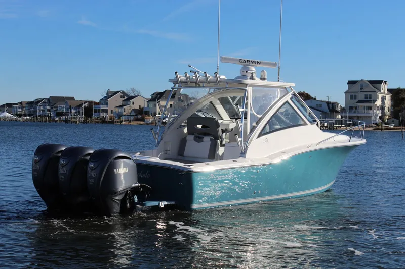 Slide: The Image of 2022 Albemarle 30 Express boat with Yamaha engines on a calm waterfront. - 6