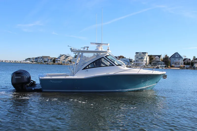 Slide: The Image of 2022 Albemarle 30 Express boat on calm water near coastal homes. - 9