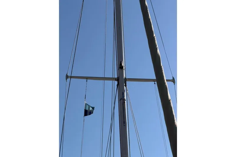 Slide: The Image of Mast of 1984 Sabre 34-1 sailboat with flag against clear blue sky. - 23