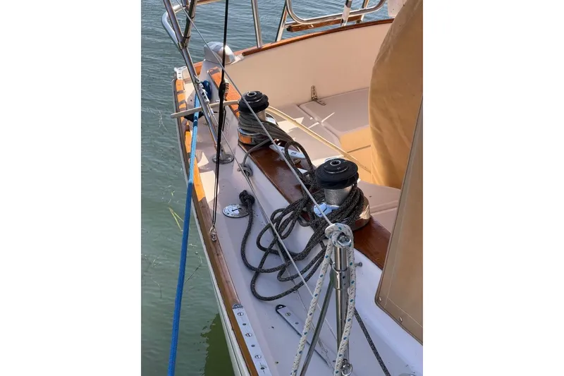 Slide: The Image of 1984 Sabre 34-1 sailboat deck with winches and ropes, docked on calm water. - 25