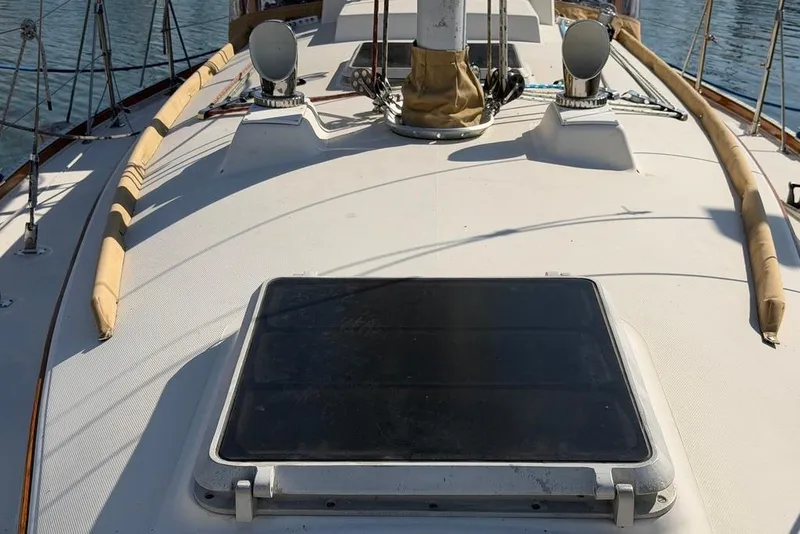 Slide: The Image of 1984 Sabre 34-1 sailboat deck with hatches and rigging, docked on calm water. - 36