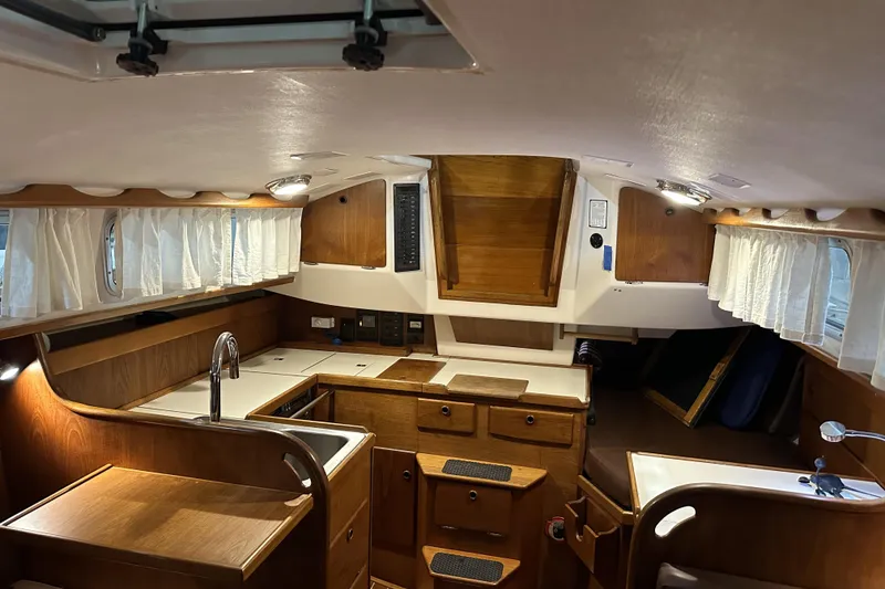 Slide: The Image of 1984 Sabre 34-1 yacht interior with wooden cabinetry and compact kitchen area. - 43