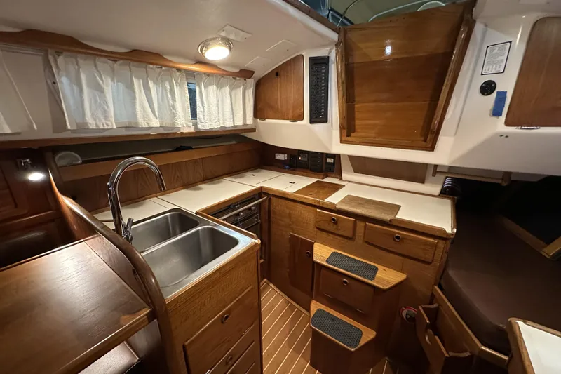 Slide: The Image of 1984 Sabre 34-1 yacht interior kitchen with wooden cabinetry and dual sink. - 44
