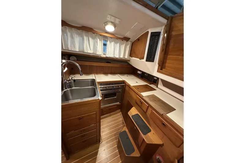 Slide: The Image of 1984 Sabre 34-1 yacht interior kitchen with wooden cabinetry and stainless steel sink. - 47
