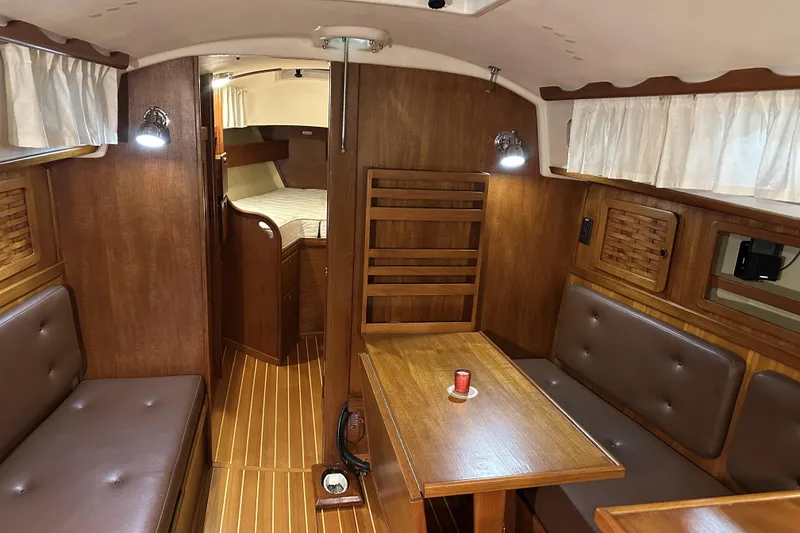 Slide: The Image of 1984 Sabre 34-1 yacht interior with wood finish, cozy seating, and dining area. - 56