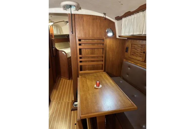 Slide: The Image of 1984 Sabre 34-1 yacht interior with wooden table and seating area. - 61