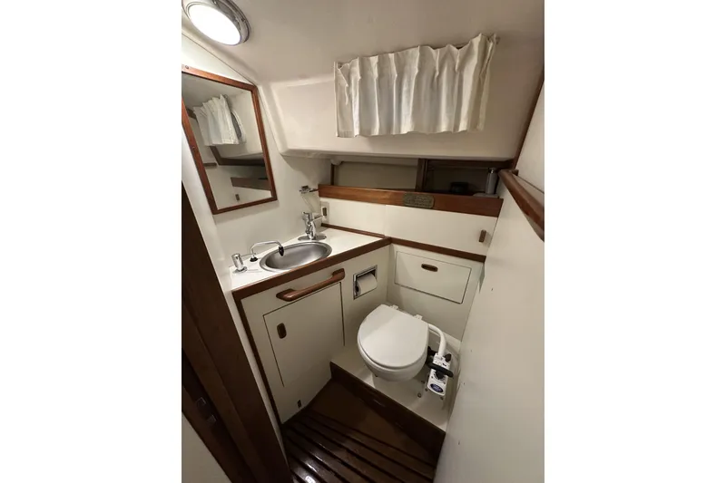 Slide: The Image of 1984 Sabre 34-1 yacht bathroom with sink, toilet, and wooden accents. - 67