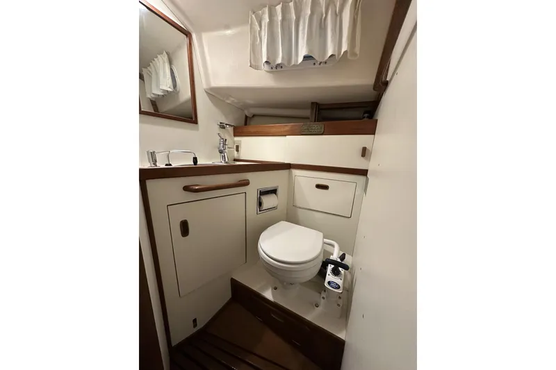 Slide: The Image of 1984 Sabre 34-1 yacht bathroom with toilet, sink, and storage cabinets. - 68
