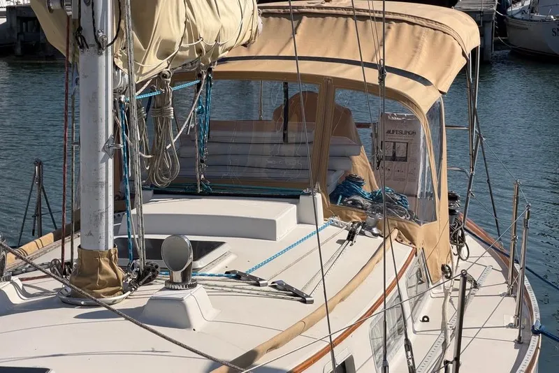 Slide: The Image of 1984 Sabre 34-1 sailboat with tan canvas cover in a marina setting. - 7
