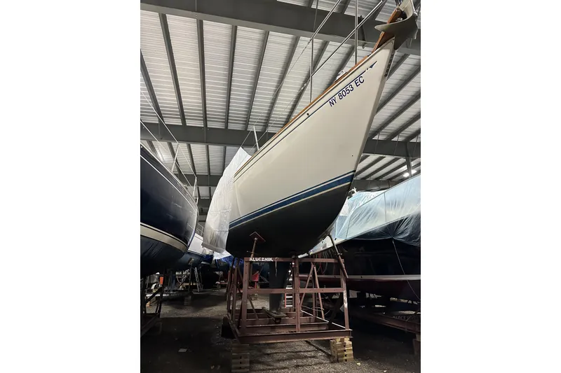 Slide: The Image of 1984 Sabre 34-1 sailboat in storage, elevated on stands, under a metal roof. - 70