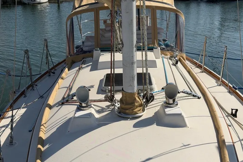 Slide: The Image of 1984 Sabre 34-1 sailboat deck with mast and railing, docked on calm water. - 9