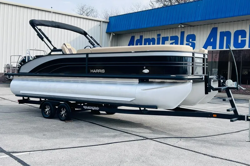 The Image of 2024 Harris Sunliner 250 pontoon boat on trailer outside dealership. - 0