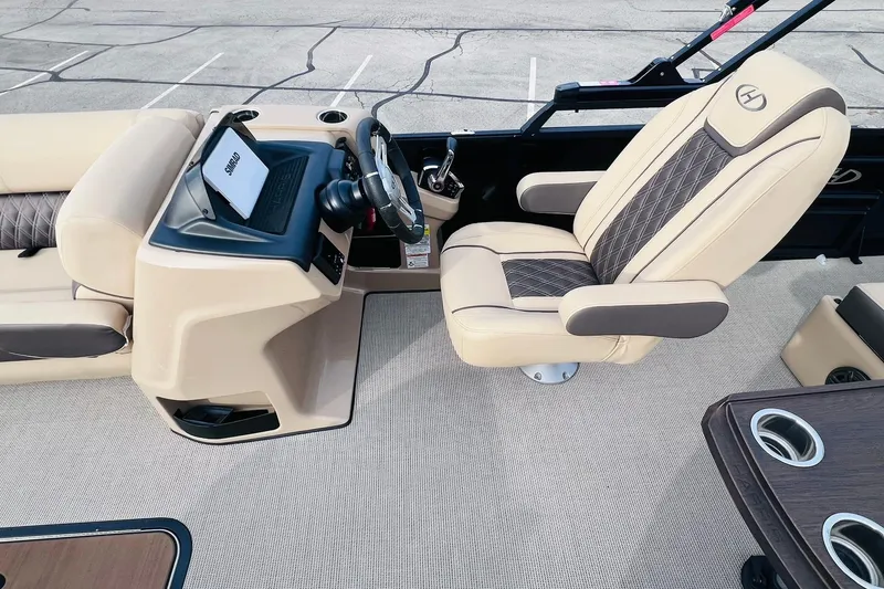 Slide: The Image of 2024 Harris Sunliner 250 boat interior with beige seating and modern dashboard. - 12