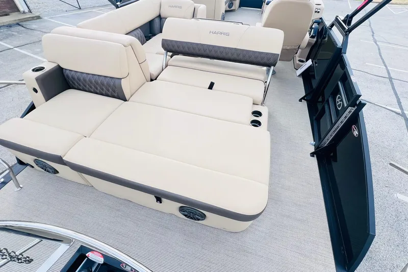 Slide: The Image of 2024 Harris Sunliner 250 boat interior with beige seating and cup holders. - 16