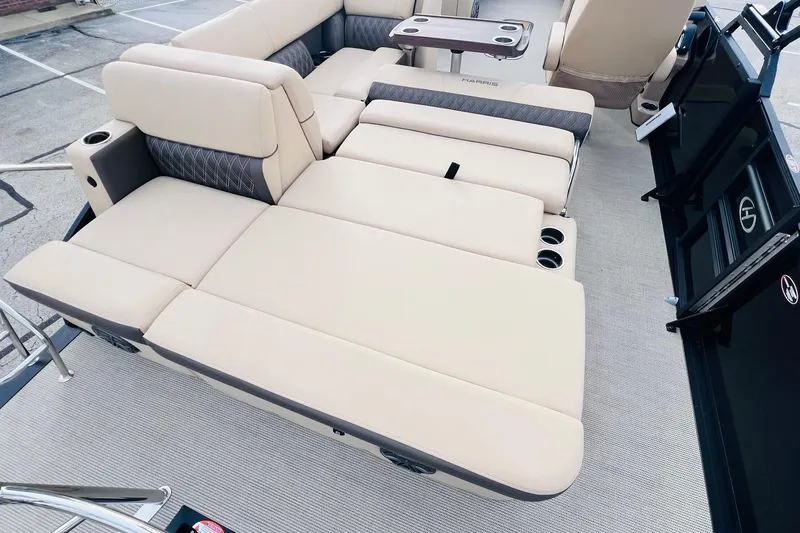 Slide: The Image of 2024 Harris Sunliner 250 boat interior with beige seating and cup holders. - 18