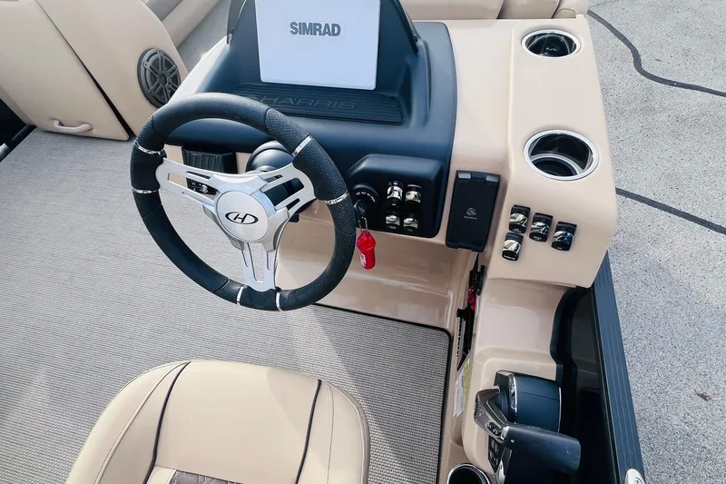 Slide: The Image of 2024 Harris Sunliner 250 boat dashboard with steering wheel and control panel. - 20