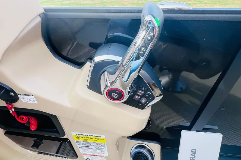Slide: The Image of 2024 Harris Sunliner 250 boat throttle control with start/stop button and safety features. - 21