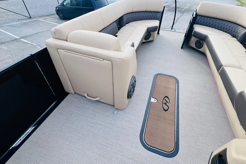 Slide: The Image of 2024 Harris Sunliner 250 boat interior with beige seating and wood-accented flooring. - 29