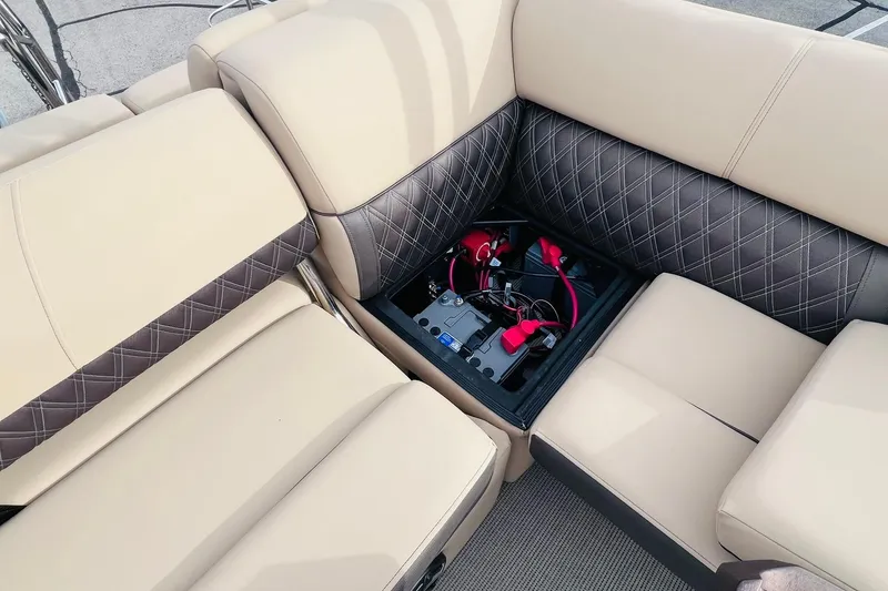 Slide: The Image of 2024 Harris Sunliner 250 boat seating with hidden battery compartment, featuring beige and brown upholstery. - 36