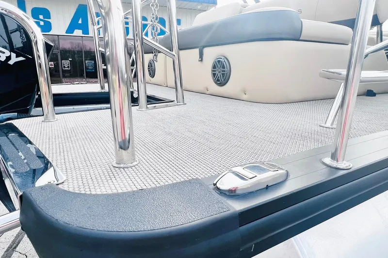 Slide: The Image of 2024 Harris Sunliner 250 boat deck with stainless steel railings and cushioned seating. - 37