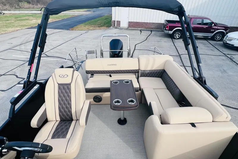 Slide: The Image of 2024 Harris Sunliner 250 boat interior with beige seating and a central table. - 9