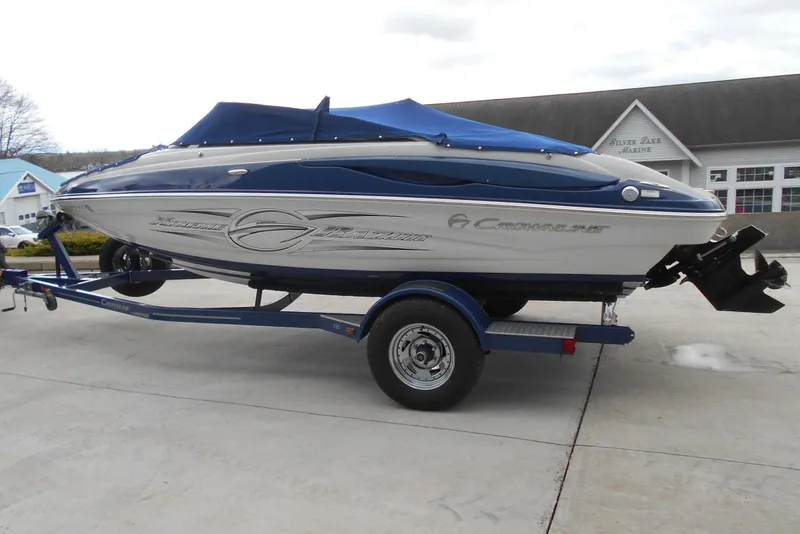 Slide: The Image of 2012 Crownline 205 SS boat on trailer, blue and white design, parked at marina. - 5